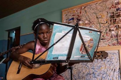 Una de las siete alumnas de clases de guitarra, con edades entre 9 y 15 años. El profesor de guitarra, Pascal, tiene 16 años y es un antiguo alumno de la escuela.
En las culturas de tradición oral, como es el caso de Burkina Faso, en África del Oeste, la música y la danza están presentes en todos los rituales y momentos clave de la vida: como manifestación de lo profano o de lo sagrado, para vehicular mensajes sociopolíticos, históricos o amorosos, durante las cosechas, los ritos de iniciación o los encuentros sociales. En Burkina Faso existen alrededor de 60 grupos étnicos con diferentes tipos de instrumentos y melodías, constituyendo un rico elenco de expresión cultural. A este país, situado en el corazón de la franja del Sahel, llegó María Behrens, una violinista alemana hace 10 años y creó la Asociación Musical para los Niños del Mundo (AMEM), la primera escuela donde los instrumentos de cuerda clásicos flirtean con los instrumentos tradicionales del país.