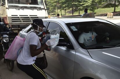 Nigeria. El grueso de la fuerza laboral africana se concentra en empleos informales. Y hay que innovar para buscarse la vida. Como esta vendedora de carretera de Lagos, que ahora ofrece mascarillas protectoras entre los conductores durante un atasco el 26 de marzo de 2020. Ese mismo día, el Gobierno alertó de que las infecciones por COVID-19 estaban aumentando e impuso un periodo de aislamiento en la ciudad.