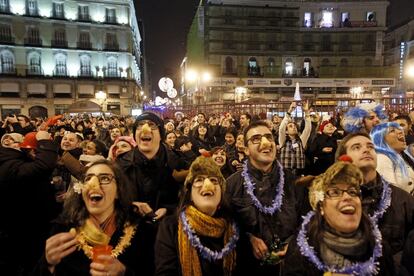 Miles de personas toman uvas para celebrar la Nochevieja en la Puerta del Sol de Madrid.