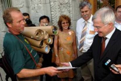 El presidente del sindicato noruego de granjeros, Bjarne Undheim (iz.), el miembro del sindicato suizo de granjeros Heidi Bravo (2 iz.) y el presidente del sindicato de granjeros suizos, Hansjoerg Walter (3 iz.), entregan diversos mensajes de granjeros neozelandeses al presidente del grupo de negociación agrícola de la OMT, Tim Grosser (d.).