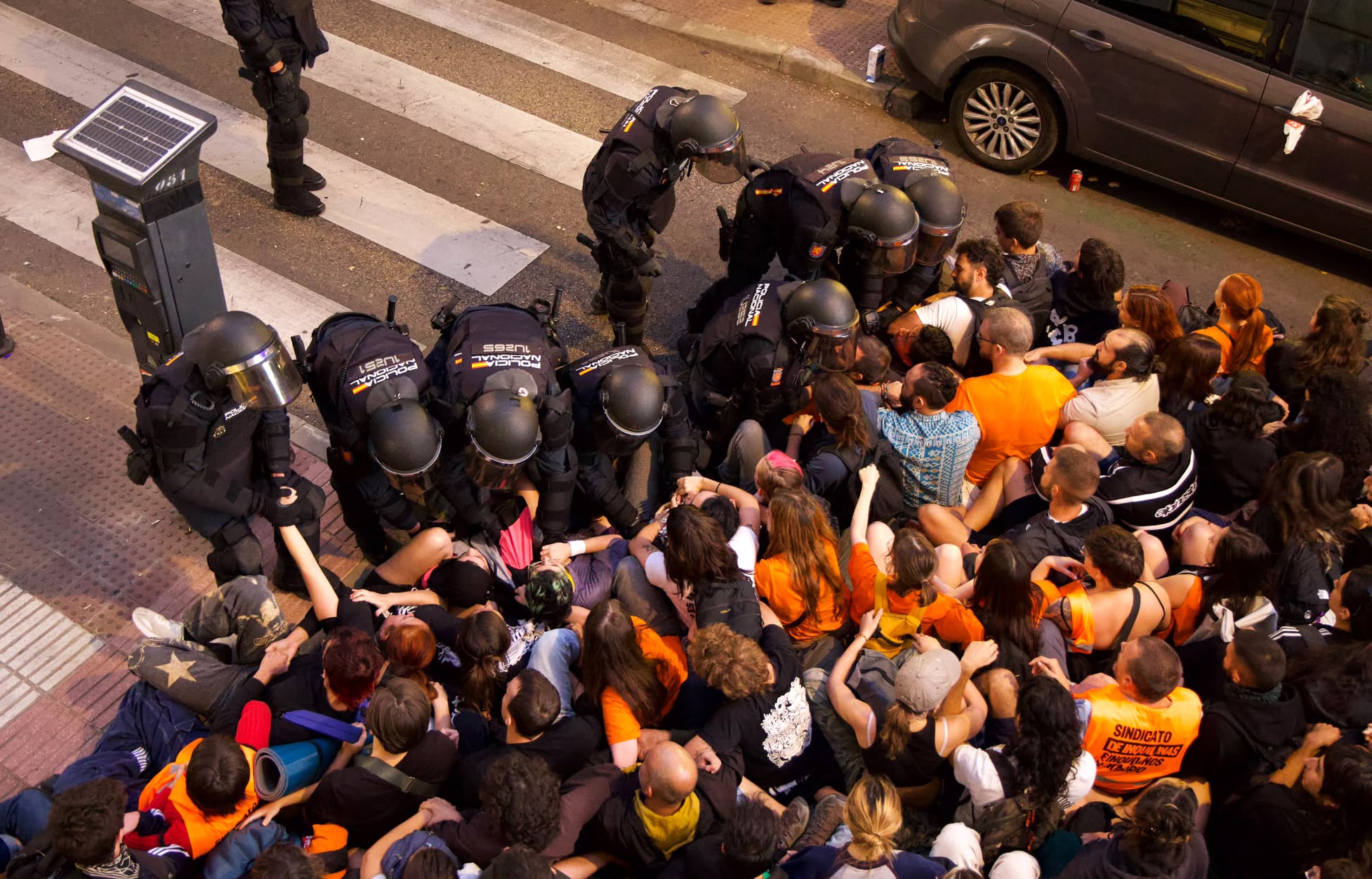 Agentes de policía retiran a los manifestantes que bloquean la calle.