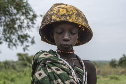 El proceso de transculturación ha derivado en una cada vez más frecuente presencia de objetos inverosímiles o absurdos en la decoración que las tribus adoptan para ser fotografiados. En la imagen, una niña del poblado Mursi de Marreke en el Parque Nacional de Mago, posa vestida con una manta de tejido sintético y un casco de obrero procedente de la cercana construcción de una planta azucarera.