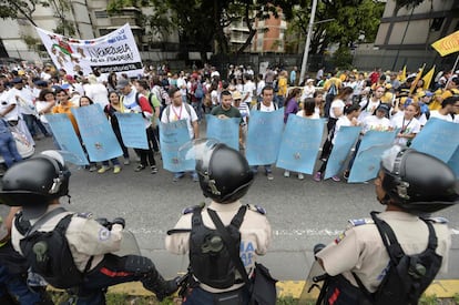Policía venezolana antidisturbios frente a los manifestantes antes de la marcha, en Caracas.