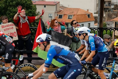 FOTODELDIA POIO (PONTEVEDRA), 09/09/2025.- Los ciclista del equipo Israel Premier Tech pasan ante las protestas propalestina durante la etapa 16 de la Vuelta Ciclista a España que se disputó este martes entre Poio y Mos-Castro de Herville (Pontevedra), de 167.9 km de recorrido. EFE/ Lavandeira Jr