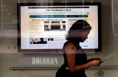 Una mujer lee el 'Post' tras el anuncio de compra de Bezos, el pasado miércoles. / Getty