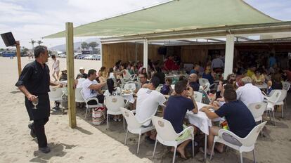 Un camarero atiende un chiringuito en una playa de M&aacute;laga.