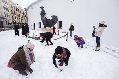 Unas jóvenes hacen un muñeco de nieve junto a la estatua del torero Cayetano Ordoñez que se encuentra a la entrada de la plaza de toros de Ronda (Málaga), tras la intensa nevada caída durante la pasada madrugada.