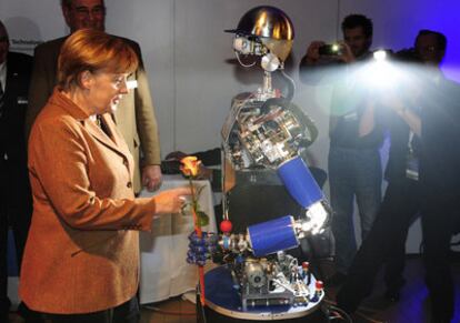 Un robot da la bienvenida a la canciller alemana, Angela Merkel, a su llegada al congreso del CDU.