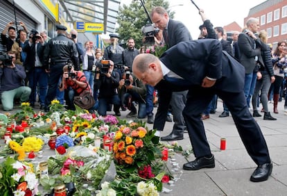 El alcalde de Hamburgo, Olaf Scholz, deja flores en el lugar del ataque en un supermercado en el que muri&oacute; una persona.