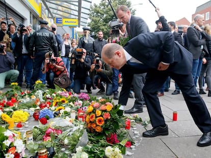 El alcalde de Hamburgo, Olaf Scholz, deja flores en el lugar del ataque en un supermercado en el que muri&oacute; una persona.