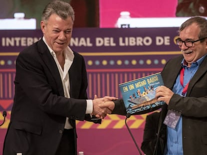 Juan Manuel Santos le regala el libro 'En un mismo barco' a Rodrigo Londoño en la FIL de Guadalajara del 2019.