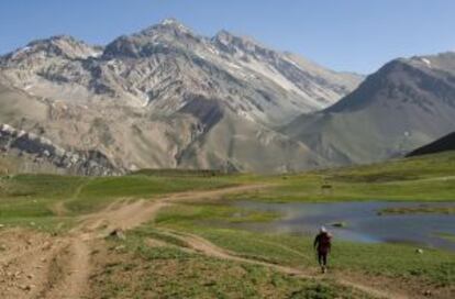 Un senderista pasa junto a la Laguna de Los Horcones, en la ruta de aproximación al Aconcagua (Argentina).