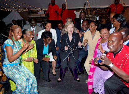 Hillary Clinton disfruta de la actuación de un grupo de danza tradicional en un restaurante de Nairobi el miércoles por la noche.