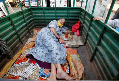 Una enferma con coronavirus espera en la parte de carga de un vehículo, frente a un hospital covid, en Ahmedabad. Se trata del quinto día consecutivo que las autoridades de India registran más de 300.000 casos en un solo día.