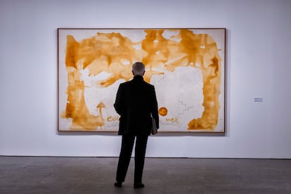 Un hombre observa la obra 'Celebració de la mel' de Tàpies, expuesto en la gran exposición dedicada al autor en el Museo Nacional Centro de Arte Reina Sofía de Madrid.