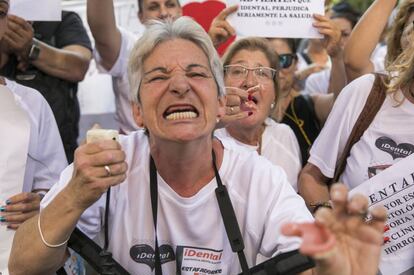 Una afectada por el cierre de las clínicas iDental muestra el estado de su boca durante la concentración de este miércoles.