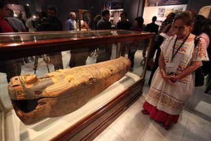 Visitantes del museo de El Cairo observan la momia recién restituída.