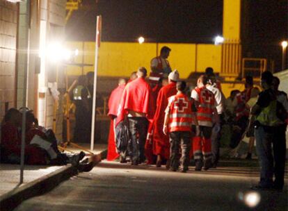 Policías nacionales y miembros de la Cruz Roja atienden a varios inmigrantes que llegaron al puerto de Cartagena.