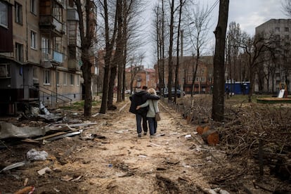 Una pareja pasa junto a un edificio dañado por los bombardeos, este domingo en Járkov (noreste). Rusia y Ucrania han llevado a cabo un intercambio de prisioneros, según la defensora de los Derechos Humanos rusa, Tatiana Moskalkova.