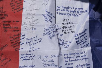 Mensajes en recuerdo a las víctimas del atentado escritos en una bandera nacional francesa, el 15 de julio de 2016.