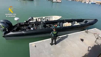 Un agente de la Guardia Civil frente a una narcolancha intervenida en el Guadalquivir en septiembre.