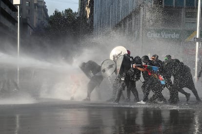 Manifestantes son reprimidos con agua a presión durante una protesta contra el Gobierno de Chile en Santiago el 20 de noviembre.