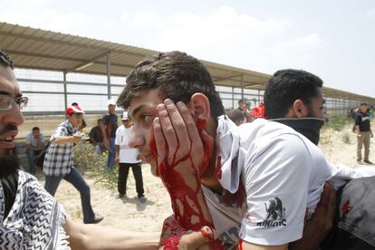 Varios palestinos llevan a un joven herido después de que los soldados israelíes dispararan contra una manifestación en el puesto fronterizo de Erez, al norte de la Franja de Gaza.