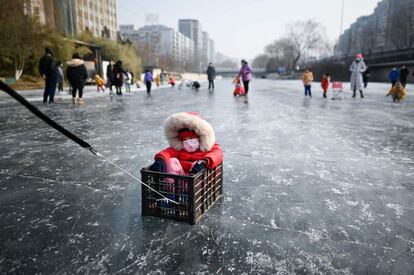 Una niña disfruta de una jornada en un lago helado en Pekín (China). El Ministerio de Salud de China ha registrado este viernes otros 105 casos de coronavirus, de los cuales 94 son de transmisión comunitaria y sólo nueve llegados desde el extranjero.