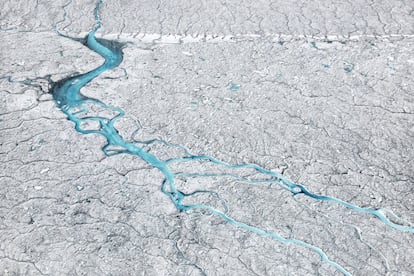 El agua del deshielo fluye a 70 kilómetros al sureste del asentamiento de Ilulissat, en Groenlandia (2014). La presencia de crioconita (cenizas y hollín), depositada en la superficie de la capa de hielo, incrementa la absorción de calor y acelera el proceso de derretimiento de los glaciares.