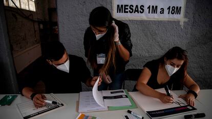 Funcionarios electorales preparan una mesa de votación en Santiago de Chile para el referéndum constitucional de este domingo.