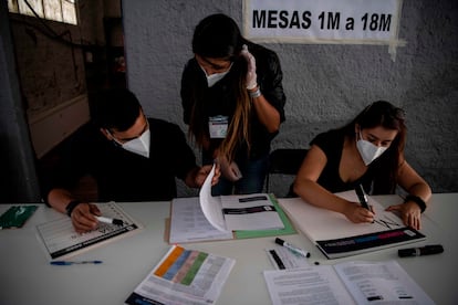 Funcionarios electorales preparan una mesa de votación en Santiago de Chile para el referéndum constitucional de este domingo.