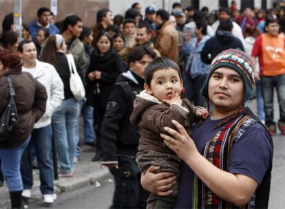Inmigrantes bolivianos esperan su turno para votar en las elecciones presidenciales de su país.