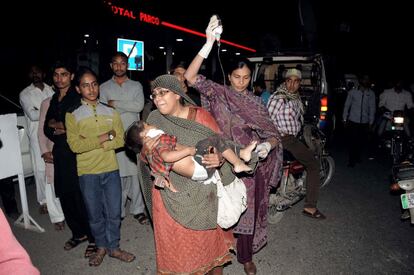 Varias personas trasladan a un niño herido al hospital en Lahore, después de la explosión de una bomba.