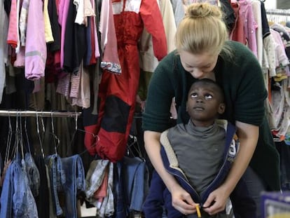 Una voluntaria pone una chaqueta en un ni&ntilde;o refugiado este mi&eacute;rcoles en M&uacute;nich (Alemania).