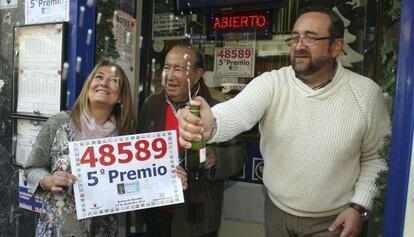 El lotero Carlos Álvarez entre sus hijos Nacho y Mar en la administración número 4 de Benidorm dónde se ha vendido íntegramente un quinto premio.