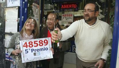 El lotero Carlos &Aacute;lvarez entre sus hijos Nacho y Mar en la administraci&oacute;n n&uacute;mero 4 de Benidorm d&oacute;nde se ha vendido &iacute;ntegramente un quinto premio.