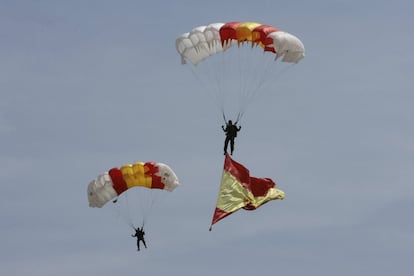 Miembros de la Brigada Paracaidista han tomado tierra portando una bandera de España que se ha izado portada por personal militar de los tres Ejércitos y la Guardia Civil.