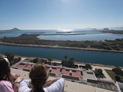 Dos personas contemplan el puerto inacabado desde su vivienda el viernes pasado.