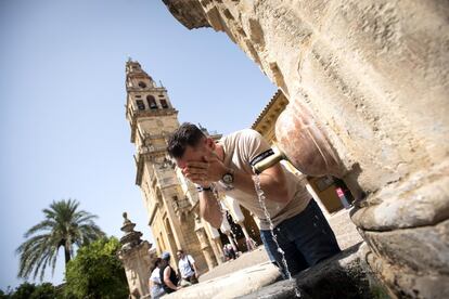 El domingo continuará haciendo mucho calor en el archipiélago canario y en la Península se comenzará a notar un ligero alivio en el tercio norte, con una bajada de las temperaturas en el alto Ebro, donde puede ser notable. En la imagen, un hombre se refresca en la fuente del Patio de los Naranjos de la mezquita-catedral de Córdoba.