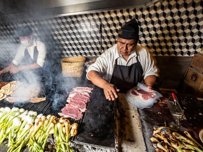 Los cocineros trabajan en las parrillas de la taquería.