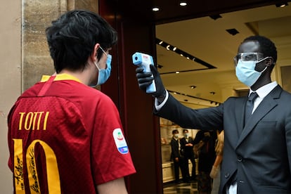 Un fan de la AS Roma entra en una tienda en el centro de Roma. 