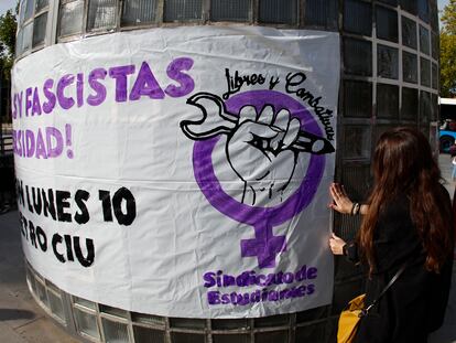 Una joven pega un cartel para convocar a una concentración organizada por el Sindicato de Estudiantes en protesta por los gritos machistas de residentes del colegio mayor Elías Ahuja.