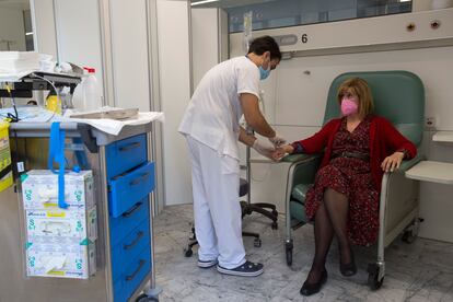 Un enfermero prepara una dosis de quimioterapia para una paciente con cáncer.