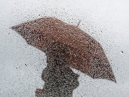 Una persona camina bajo la lluvia, el pasado lunes, junto a la playa de El Sardinero en Santander.