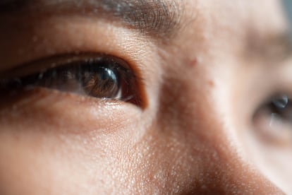 El primer plano de los ojos de una joven al aire libre durante el amanecer.