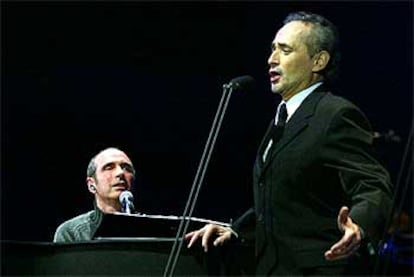 Lluís Llach al piano, a la izquierda, y José Carreras, en un momento del recital que ofrecieron en el Palau Sant Jordi. / SUSANNA SÁEZ