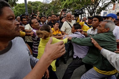 Partidarios y opositores del gobierno de Nicolás Maduro se enfrentan durante una protesta contra la sentencia del Tribunal Supremo, en Caracas. 