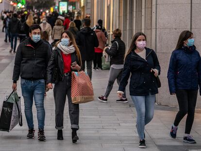 Varias personas con bolsas de diferentes comercios caminan por la calle Preciados, en Madrid, el pasado diciembre.