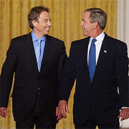 George Bush y Tony Blair, ayer mientras caminaban hacia el atril desde el que hablaron a la prensa en la Casa Blanca.