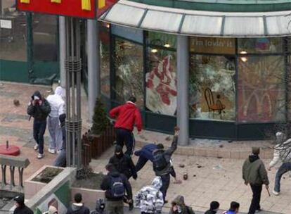 Un grupo de jóvenes serbios protesta lanzando piedras a un McDonald's del centro de Belgrado.